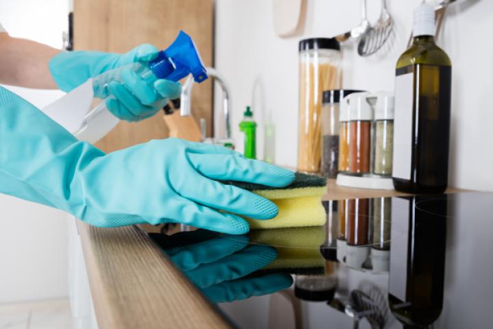 Domestic cleaner cleaning kitchen worktop